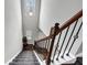 Carpeted staircase with decorative wrought iron railing and high ceilings leading to upper level at 1332 Worcester Trl, Mcdonough, GA 30253