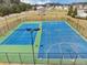Tennis and basketball courts in a fenced community area surrounded by trees at 1332 Worcester Trl, Mcdonough, GA 30253