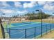 Tennis and basketball courts in a fenced community area surrounded by trees at 1332 Worcester Trl, Mcdonough, GA 30253