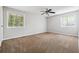 Spacious bedroom with neutral walls, ceiling fan, and natural light from two windows at 1360 Cypress Ridge Cir, Stone Mountain, GA 30083