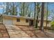 Single-story home with a attached garage, a brick foundation, and a long driveway at 1360 Cypress Ridge Cir, Stone Mountain, GA 30083