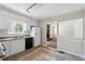 Functional kitchen with white cabinets, appliances, and tile flooring with an open view to the living room at 1360 Cypress Ridge Cir, Stone Mountain, GA 30083