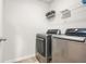 An efficient laundry room complete with stainless steel washer and dryer and wire shelving at 9893 Colchester St, Douglasville, GA 30135