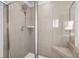 A tiled walk-in shower has glass doors, a shower head, and convenient built-in bench for accessibility at 9893 Colchester St, Douglasville, GA 30135