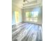 Spacious bedroom with large windows offering abundant natural light and stylish wood-look flooring at 203 Sea Marsh Ct, Fayetteville, GA 30215
