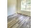 Well-lit bedroom showcasing the large window and stylish wood-look laminate flooring at 203 Sea Marsh Ct, Fayetteville, GA 30215