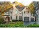 Charming two-story brick home with a manicured lawn, arched entryway, and attached two-car garage at 425 Prestwick Ct, Alpharetta, GA 30005