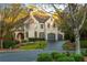 Elegant brick home featuring arched windows, a well-manicured lawn, and a circular driveway leading to a two-car garage at 425 Prestwick Ct, Alpharetta, GA 30005