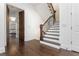 Elegant foyer boasting dark hardwood floors, staircase with iron railings, and an open doorway to the bedroom at 425 Prestwick Ct, Alpharetta, GA 30005