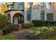 Close-up of front entrance featuring an arched entryway, decorative stone, and detailed landscaping at 425 Prestwick Ct, Alpharetta, GA 30005