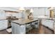 Kitchen with stainless appliances, granite countertops, an island with bar stool seating and custom white cabinetry at 425 Prestwick Ct, Alpharetta, GA 30005