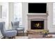 Close up of the stone fireplace with hearth and two chairs at 425 Prestwick Ct, Alpharetta, GA 30005