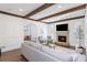 Open living room with wooden beam ceiling, fireplace, and archway to the dining room at 425 Prestwick Ct, Alpharetta, GA 30005