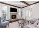 Cozy living room featuring a stone fireplace, wood beams, and shuttered windows at 425 Prestwick Ct, Alpharetta, GA 30005