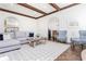 Bright living room features dark wood beams, hardwood floors and an open concept design to dining and kitchen area at 425 Prestwick Ct, Alpharetta, GA 30005