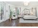 Bright main bedroom featuring a canopy bed, sitting area, and access to a private outdoor space at 425 Prestwick Ct, Alpharetta, GA 30005