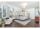 Spacious main bedroom with canopy bed, sitting area, hardwood floors and large windows at 425 Prestwick Ct, Alpharetta, GA 30005
