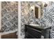 Stylish powder room featuring bold wallpaper, granite countertop, and decorative gold framed mirror at 425 Prestwick Ct, Alpharetta, GA 30005