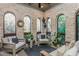 Relaxing sunroom with brick walls, arched windows offering scenic outdoor views, and comfortable seating at 425 Prestwick Ct, Alpharetta, GA 30005