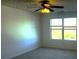 Bright bedroom with neutral carpet, a ceiling fan, and a window offering a view of trees at 10303 Waldrop Place, Decatur, GA 30034