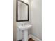 Small bathroom with pedestal sink and framed mirror at 13415 Bishops Ct, Roswell, GA 30075