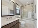 Modern bathroom featuring a glass-enclosed shower, a wide mirror over double sinks, and tiled floors at 13415 Bishops Ct, Roswell, GA 30075