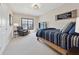 Cozy bedroom featuring neutral tones, a comfortable bed, and a reading chair with a window providing natural light at 13415 Bishops Ct, Roswell, GA 30075