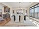 Elegant dining room with a modern chandelier, dark wood table, and beige chairs at 13415 Bishops Ct, Roswell, GA 30075