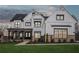 Stunning two-story home boasts white siding, black trim windows and covered porch with rocking chairs at 13415 Bishops Ct, Roswell, GA 30075
