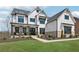 Beautiful two-story home featuring white siding, black trim windows and covered porch at 13415 Bishops Ct, Roswell, GA 30075