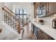 Hallway featuring staircase, hardwood floors, and view into the living room with tall windows at 13415 Bishops Ct, Roswell, GA 30075