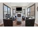 Cozy living area with a stone fireplace and abundant natural light from large windows at 13415 Bishops Ct, Roswell, GA 30075