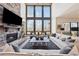 Bright living room with soaring windows, stone fireplace, and stylish furniture at 13415 Bishops Ct, Roswell, GA 30075