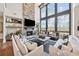 Bright and airy living room with a stone fireplace, soaring windows, and neutral furnishings at 13415 Bishops Ct, Roswell, GA 30075