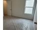Cozy bedroom with a window for natural light and flooring protected with plastic wrap at 2113 Boxwood Se Cir, Conyers, GA 30094