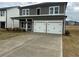 A two-story home featuring a long driveway that leads to a two-car garage, offering ample parking space at 2113 Boxwood Se Cir, Conyers, GA 30094