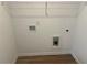 Bright laundry room featuring white walls, wood-look flooring, and hookups for laundry appliances at 2113 Boxwood Se Cir, Conyers, GA 30094