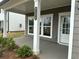 Cozy front porch with classic white columns and a view of the well-manicured landscaping at 2113 Boxwood Se Cir, Conyers, GA 30094