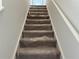 Carpeted staircase with plastic protection for easy moving, freshly painted white walls, natural light at 2113 Boxwood Se Cir, Conyers, GA 30094