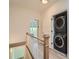 Hallway featuring a stacked washer and dryer, white wooden railing, and hardwood flooring at 8 Bass Se St, Atlanta, GA 30315