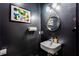 Contemporary powder room with black walls, a modern sink, mirror, and stylish lighting at 1506 Avon Sw Ave, Atlanta, GA 30311