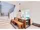 Bright dining area with a large wooden table, bench seating, modern light fixture, and stylish staircase at 1506 Avon Sw Ave, Atlanta, GA 30311