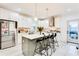 Stylish kitchen with white cabinets, a central island, bar stools, and stainless steel appliances at 1506 Avon Sw Ave, Atlanta, GA 30311