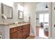 Bathroom featuring double sinks, granite counters, and an open door to the bedroom at 3635 E Paces Ne Cir # 1308, Atlanta, GA 30326