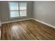 A clean bedroom with a large window, light gray walls, and laminate flooring at 3923 High Dove Sw Way # 16, Smyrna, GA 30082