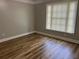 A cozy bedroom showcases wood-look flooring and a sunlit window with blinds at 3923 High Dove Sw Way # 16, Smyrna, GA 30082