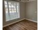 Bright bedroom featuring wood-look flooring and a large window with wooded view at 3923 High Dove Sw Way # 16, Smyrna, GA 30082