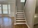 Wooden staircase with white risers next to a bay window, blending elegance and natural light at 3923 High Dove Sw Way # 16, Smyrna, GA 30082