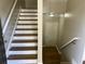 Staircase with hardwood steps and white risers, leading to a well-lit foyer at 3923 High Dove Sw Way # 16, Smyrna, GA 30082