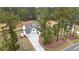 Aerial view featuring a white farmhouse style home with long driveway, three car garage and mature trees at 4025 Bullock Bridge Rd, Loganville, GA 30052